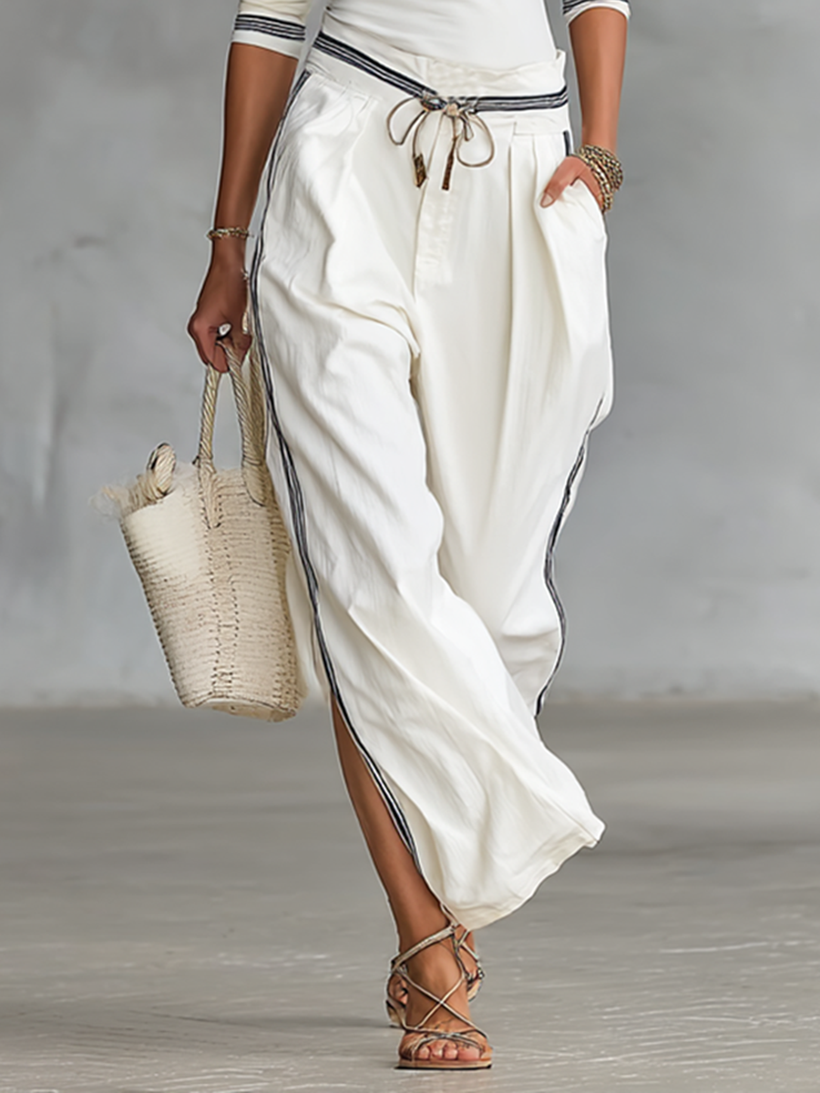 Woman in casual loungewear sport set: wide leg pants & matching top, posing. Image 4 of 6.