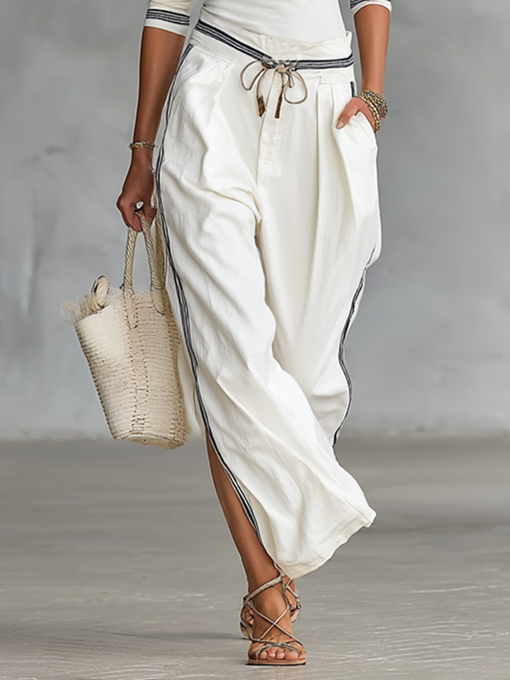 Woman in casual loungewear sport set: wide leg pants & matching top, posing. Image 4 of 6.